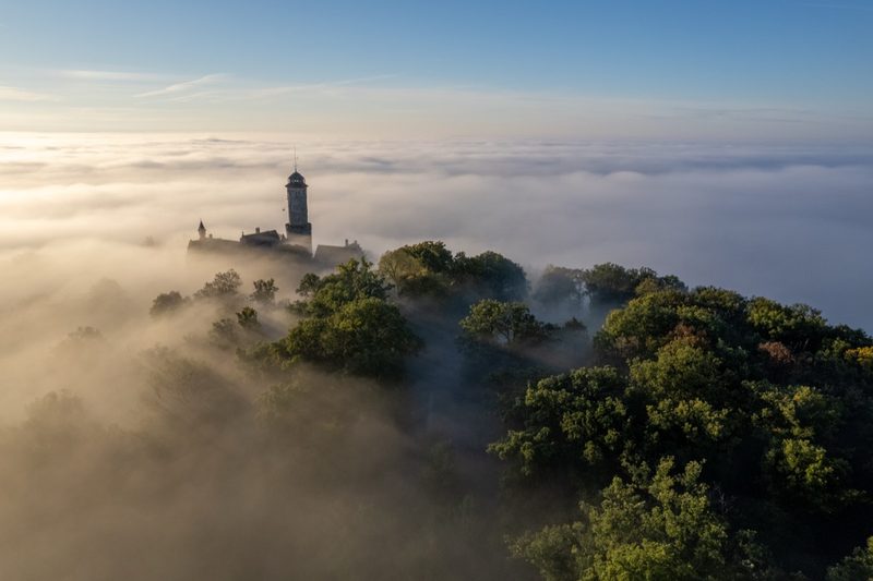 Der Bergfried ragt über das Nebelmeer, das die Stadt im Tal vollständig verhüllt. Erstes Morgenlicht. 30. September 2022.