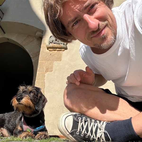 Jochen Meyer mit Dackeldame Frida vor dem Tor der Altenburg